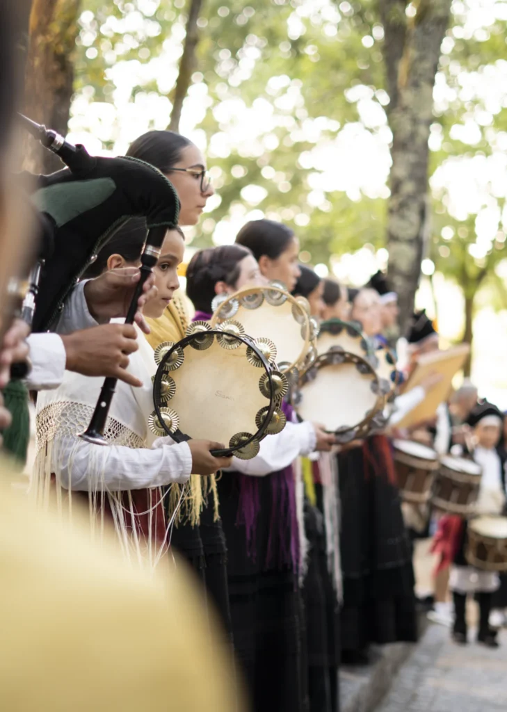 Pandeireteiras de Airiños de Arnoia tocando no desfile baixo os carballos do recinto