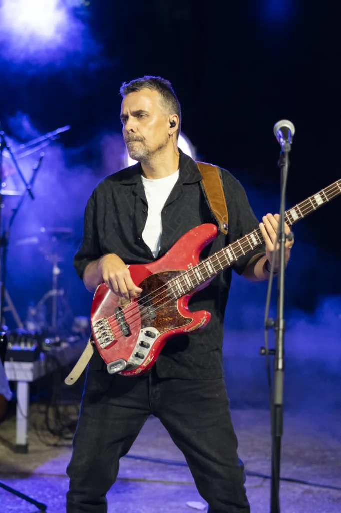 Baixista cun baixo vermello toca no concerto nocturno da Festa do Pemento de Arnoia