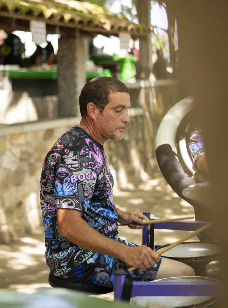 Batería dunha charanga tocando baixo o emparrado do recinto da Festa do Pemento