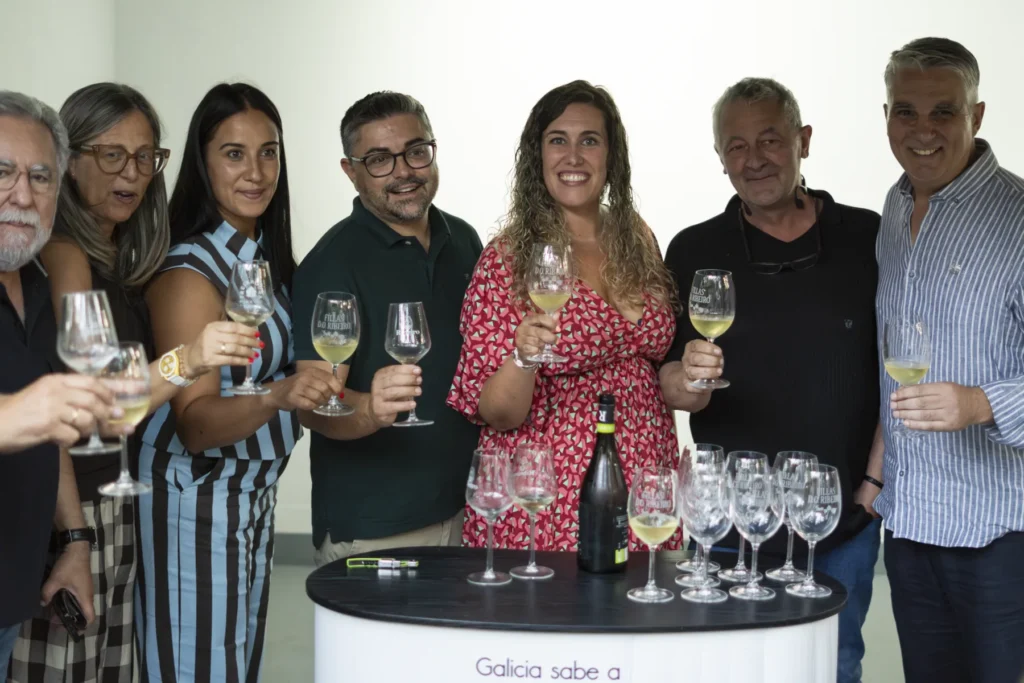 Grupo de visitantes brindando con copas de viño branco do Ribeiro durante a festa