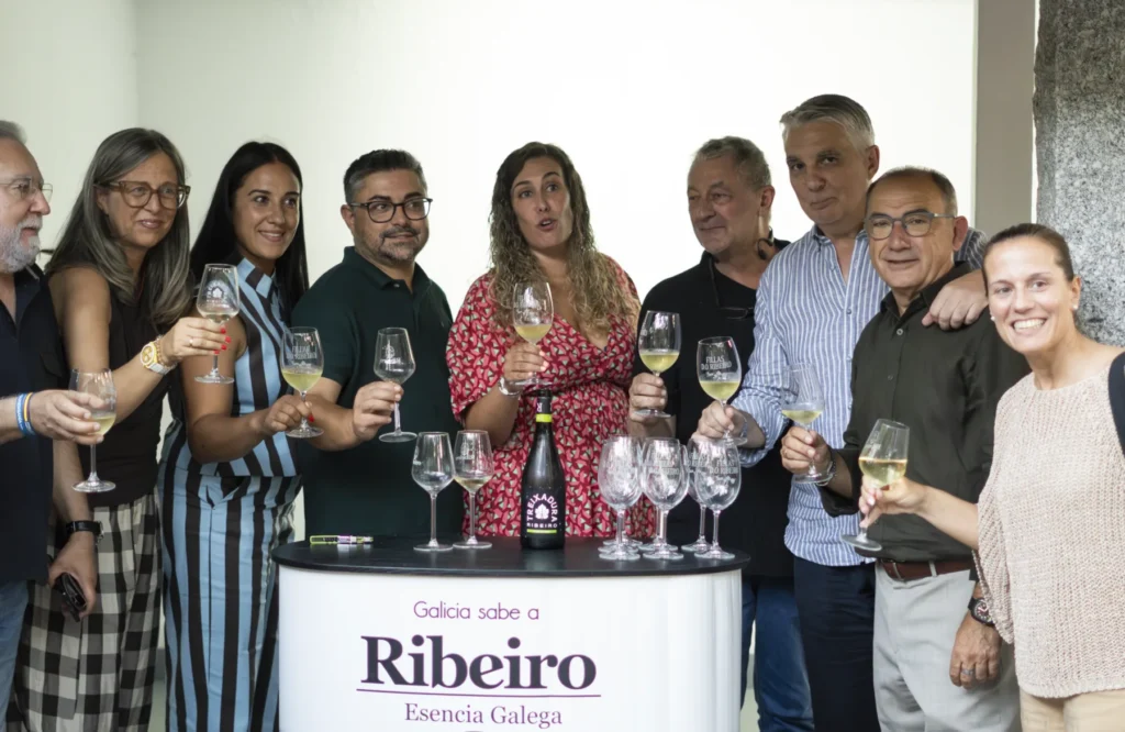 Grupo de asistentes brinda con copas de viño branco no espazo do Ribeiro