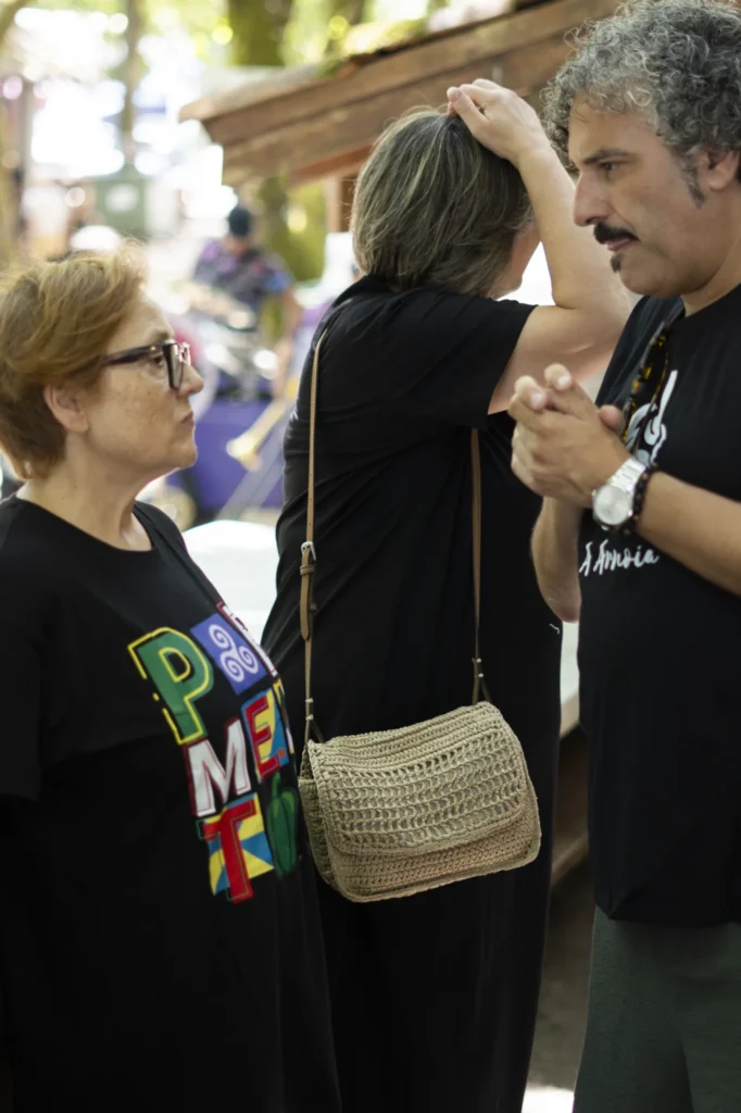 Muller coa camisola do Pemento conversando con outros veciños no recinto da festa