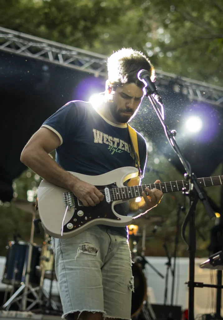 Guitarrista tocando a contraluz no escenario ao aire libre da Festa do Pemento de Arnoia