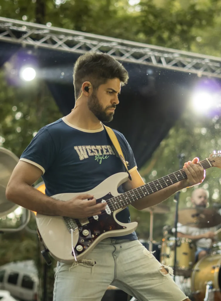 Guitarrista tocando unha guitarra eléctrica branca no escenario da Festa do Pemento de Arnoia