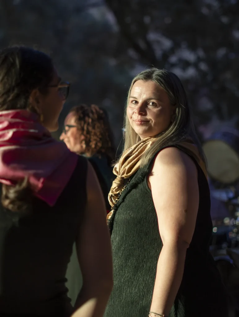 Muller cun pano dourado sorrindo á cámara coa luz cálida do atardecer na festa