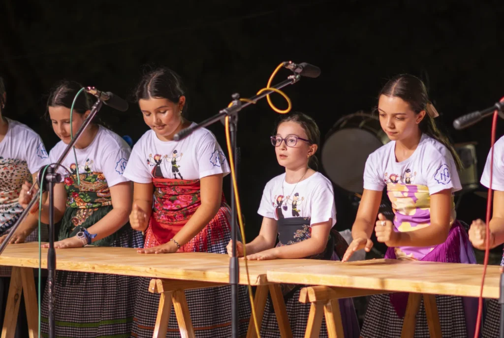 Nenas do grupo folclórico marcando o ritmo sobre as táboas de madeira no escenario