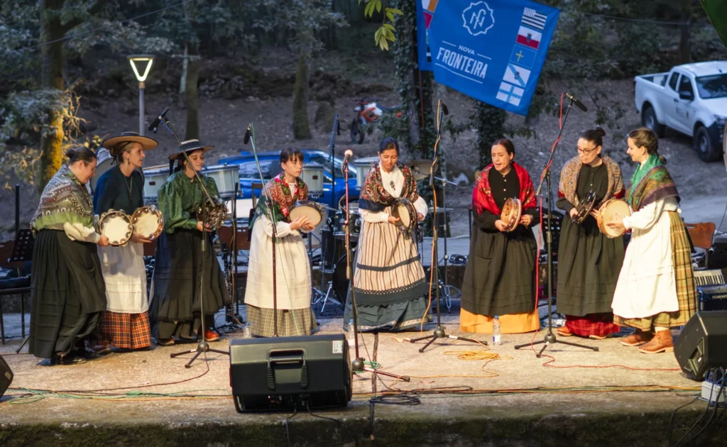 Grupo de pandereteiras con traxe tradicional actuando no escenario ao solpor