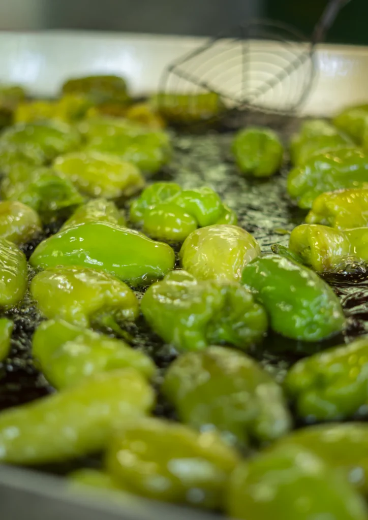 Pementos da Arnoia fritíndose en aceite quente nunha gran tixola do recinto festivo