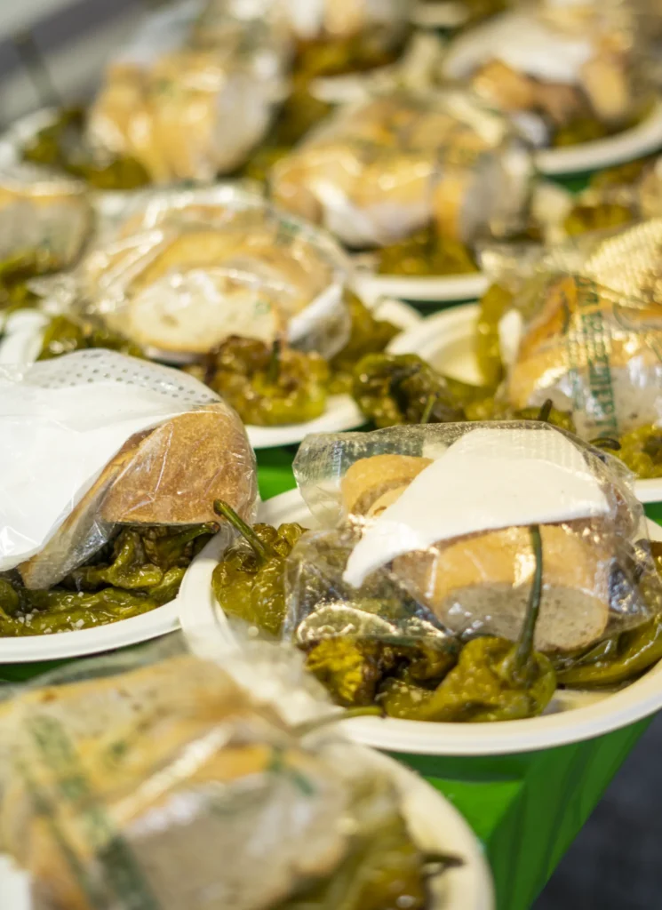 Racións de pementos fritos servidas en pratos con pan, listas para a degustación popular